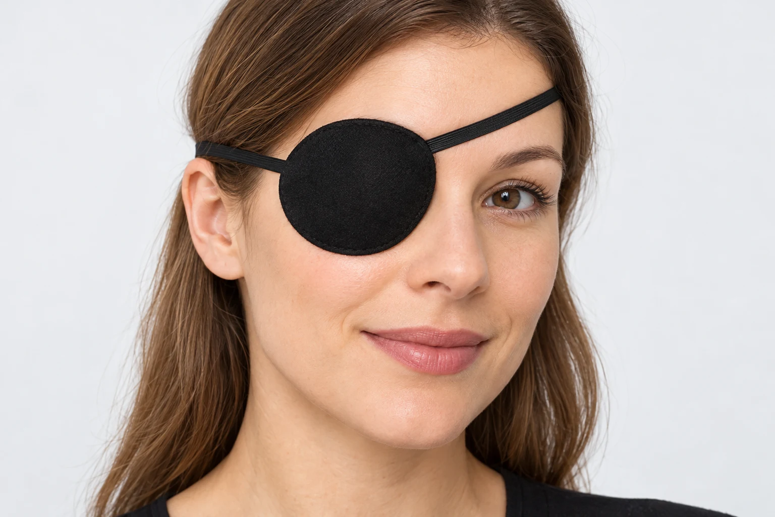 Person trägt eine schwarze Augenklappe mit Gummiband am linken Auge